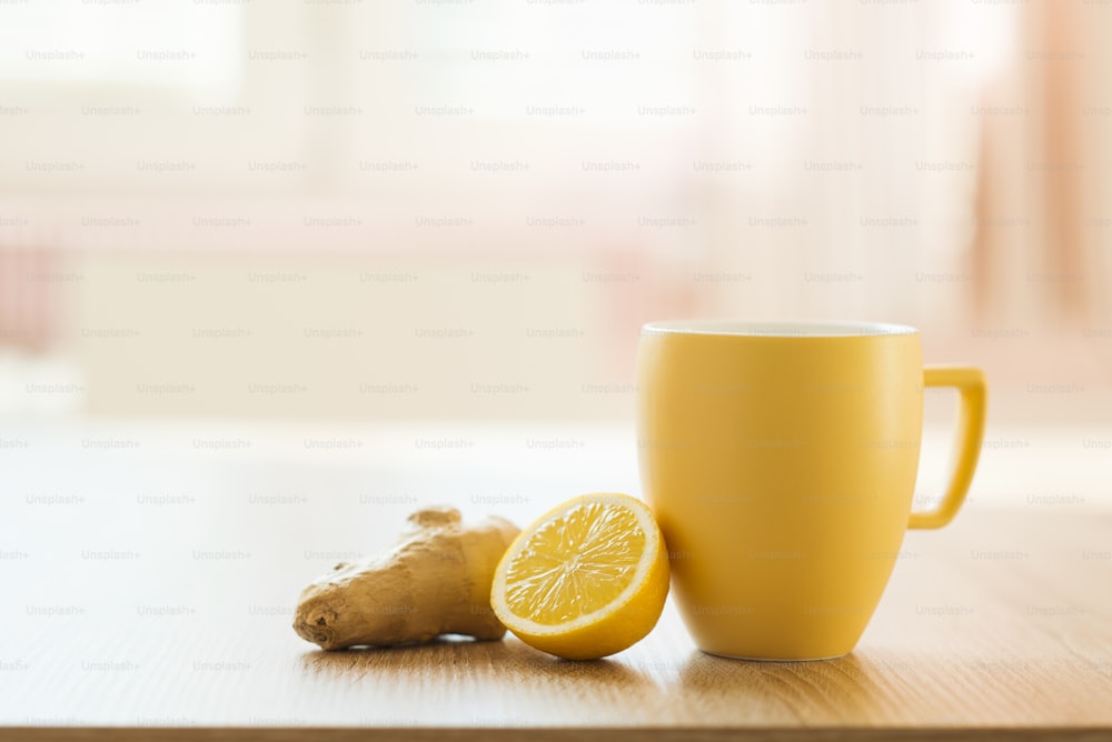 Cup of tea and lemon closeup with sunny house interior in background