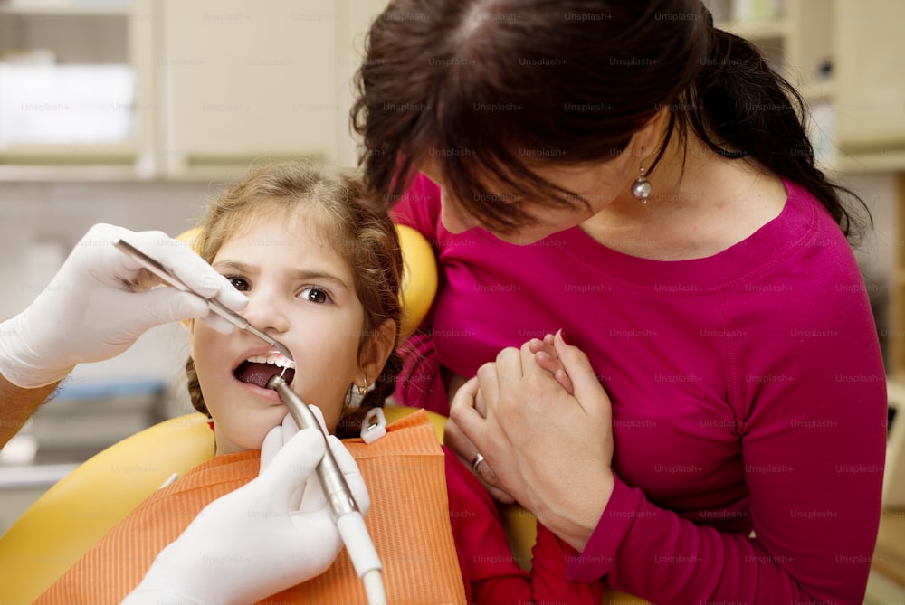 Little girl is having her teeth checked by dentist