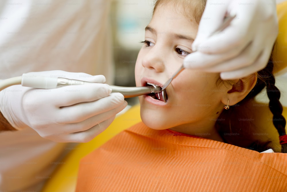 Kleines Mädchen lässt seine Zähne vom Zahnarzt untersuchen