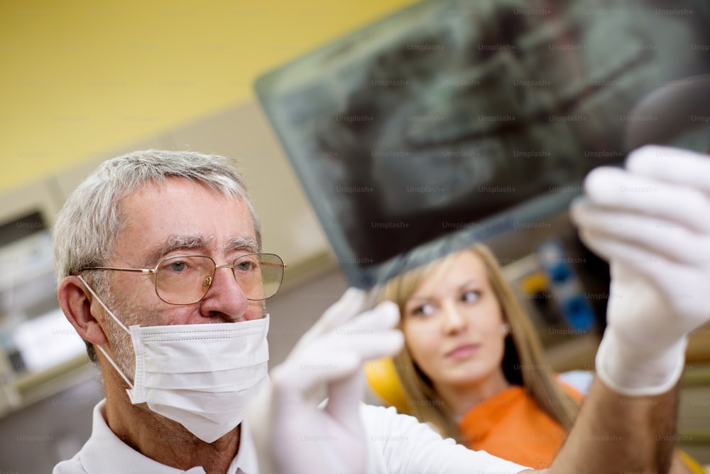 Dentist is showing the x ray of teeth to his patient