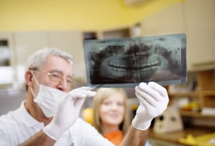 Der Zahnarzt zeigt seinem Patienten das Röntgenbild der Zähne