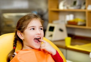 어린 소녀는 치과에서 치아를 검사하고 있습니다.