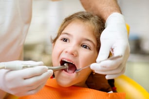 Kleines Mädchen lässt seine Zähne von einem Zahnarzt untersuchen