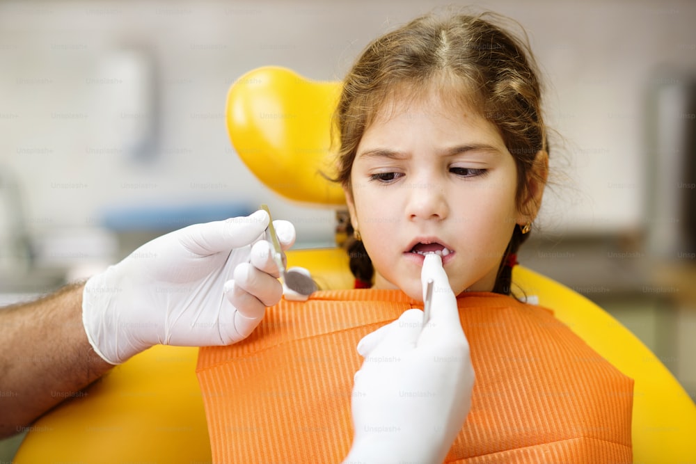 Little girl is having her teeth checked by dentist