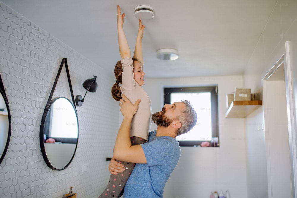 A happy father having fun with his little daughter in bathroom.