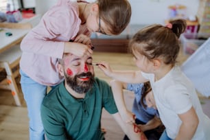 Três meninas se maquiando no pai, um dia de pais com as filhas em casa.