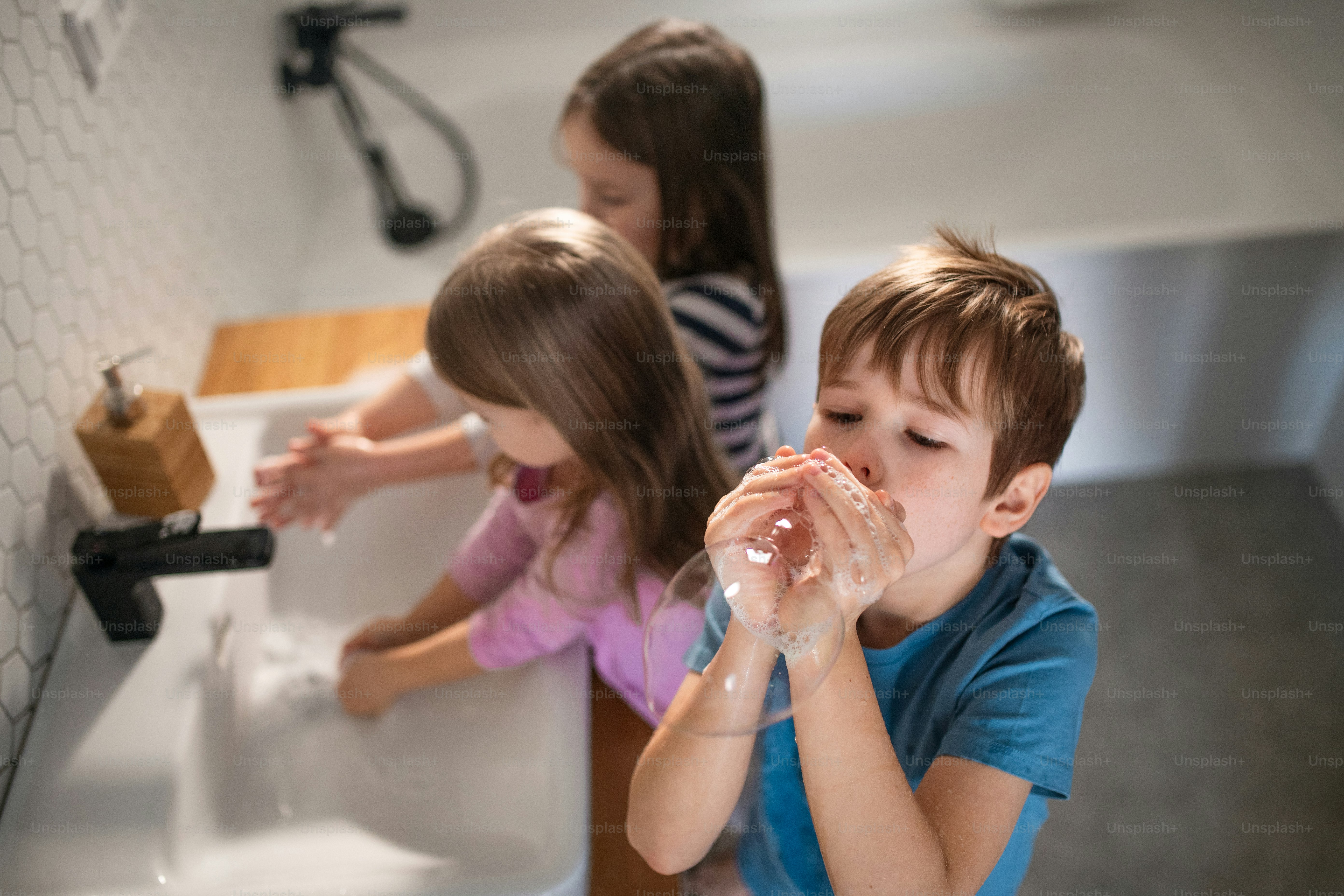 A high anbgle view of little children in bathroom, washing hands and ...