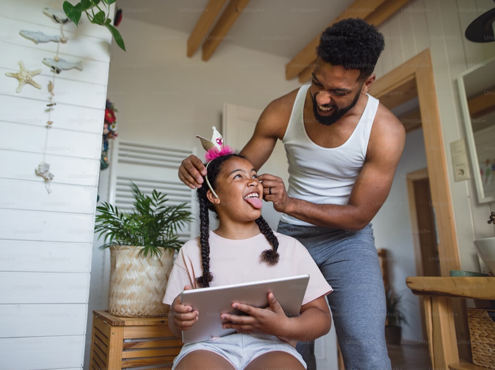 A happy young man with small sister indoors at home, having fun in bathroom.