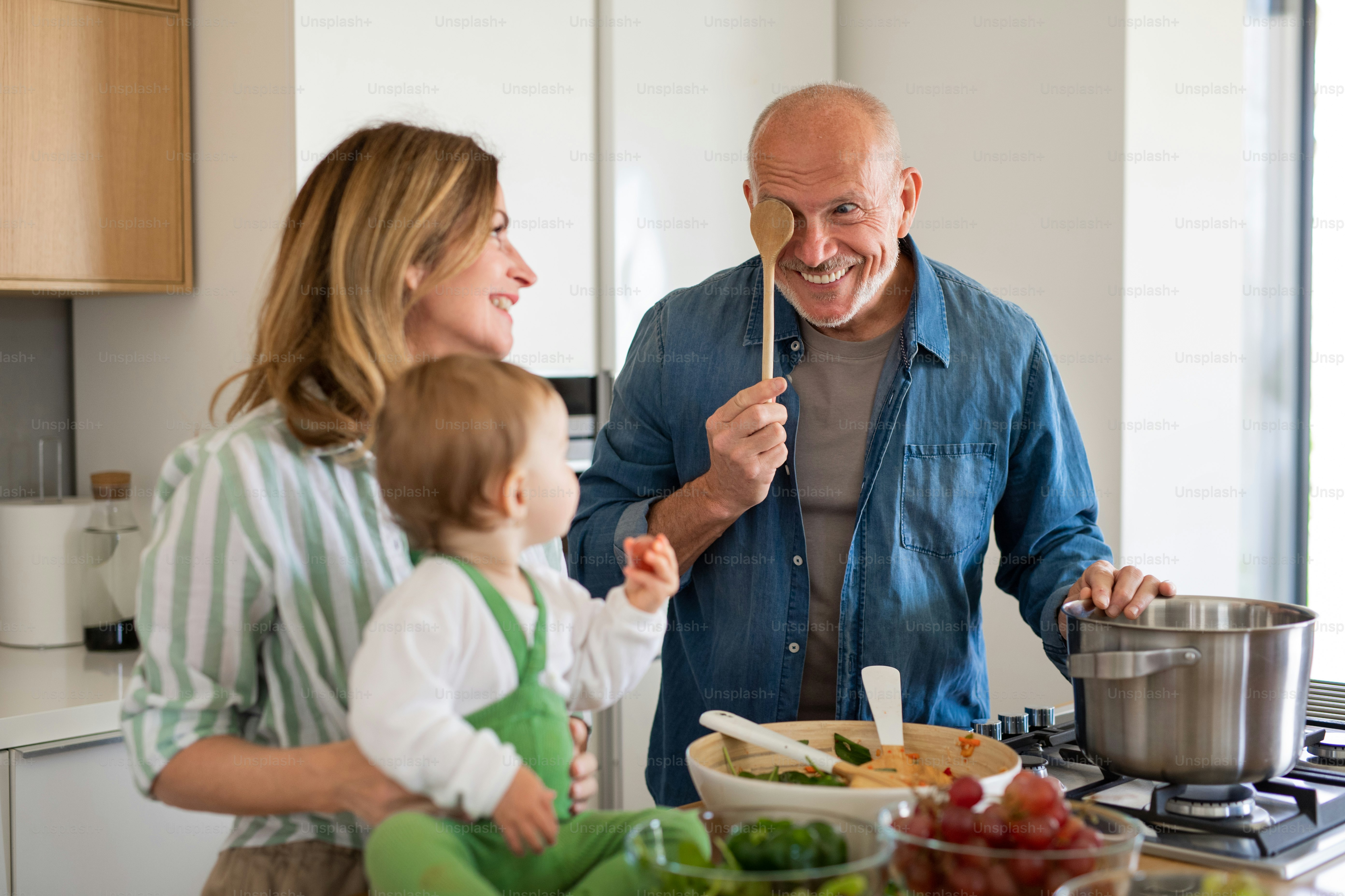 Parent preparing homemade baby food in a kitchen with fresh vegetables