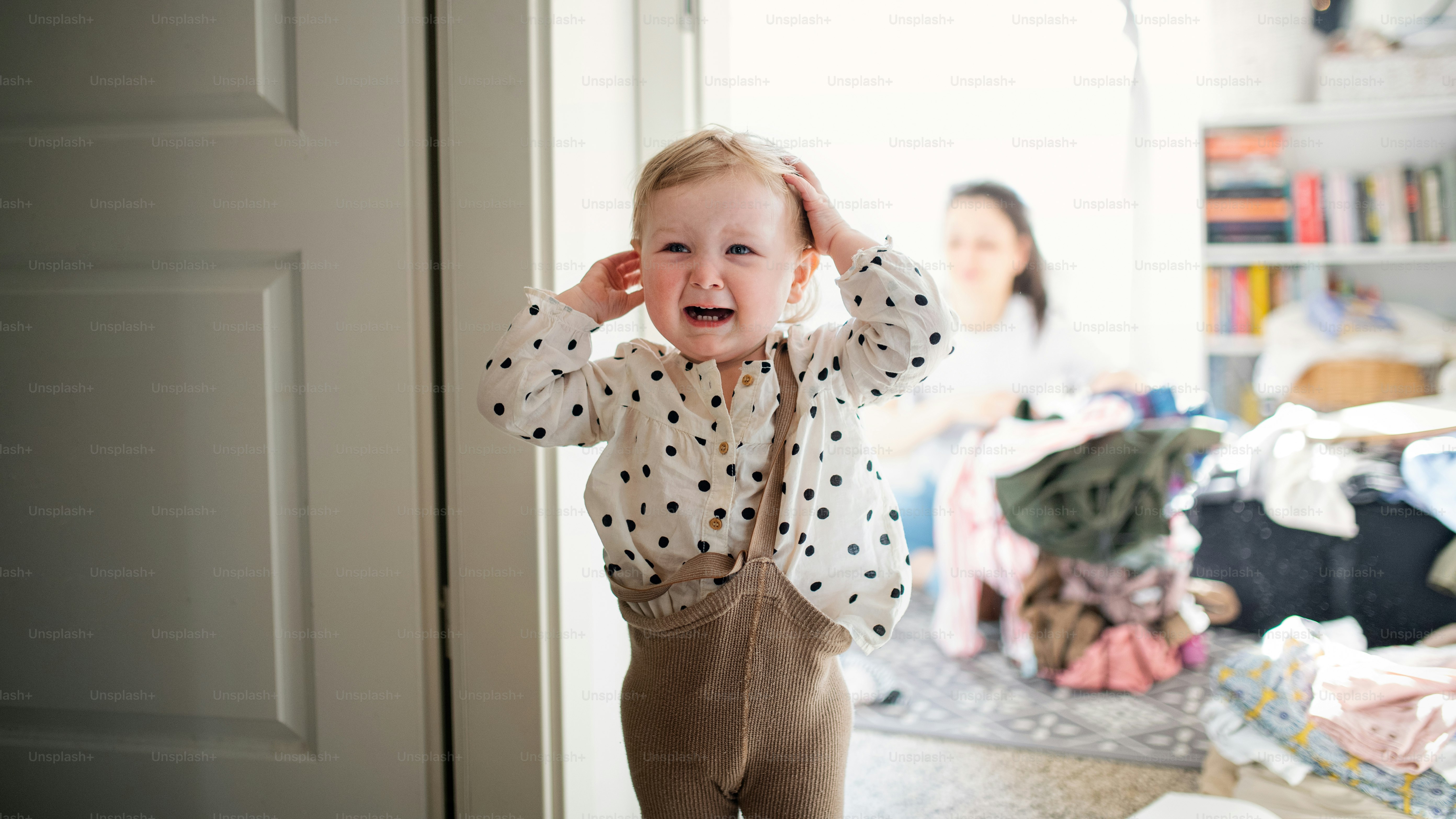 Une petite fille bouleversée dans la chambre à la maison, pleurant.