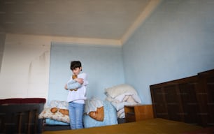 Pobre menina triste sentada no quarto dentro de casa, conceito de pobreza.
