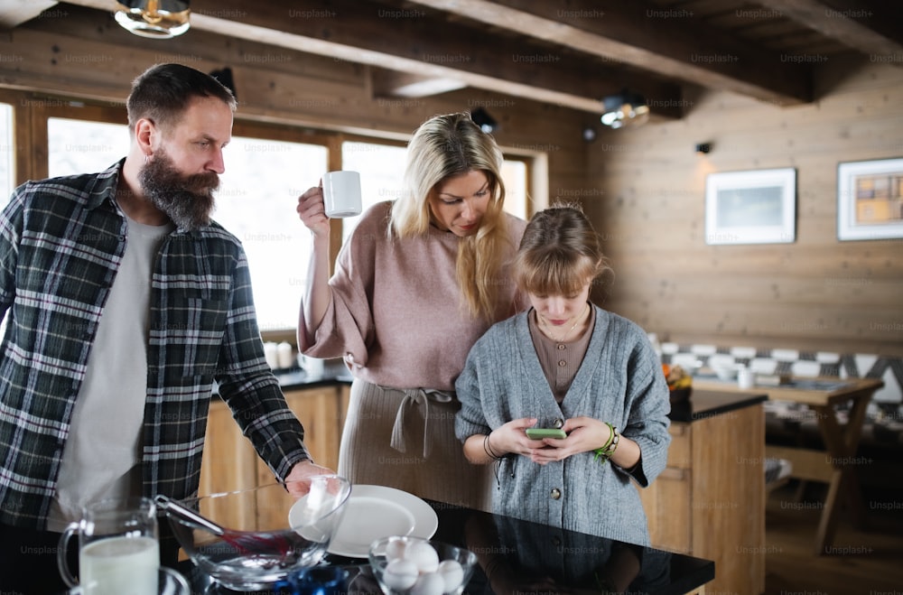 Happy family with small daughter cooking indoors, winter holiday in private apartment.