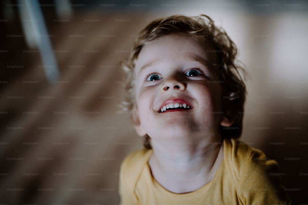 Una vista superior de un niño pequeño en casa, mirando hacia arriba. Un primer plano.