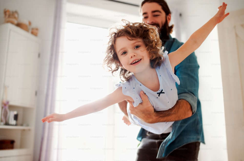 Uma menina pequena com pai jovem no banheiro em casa, se divertindo.