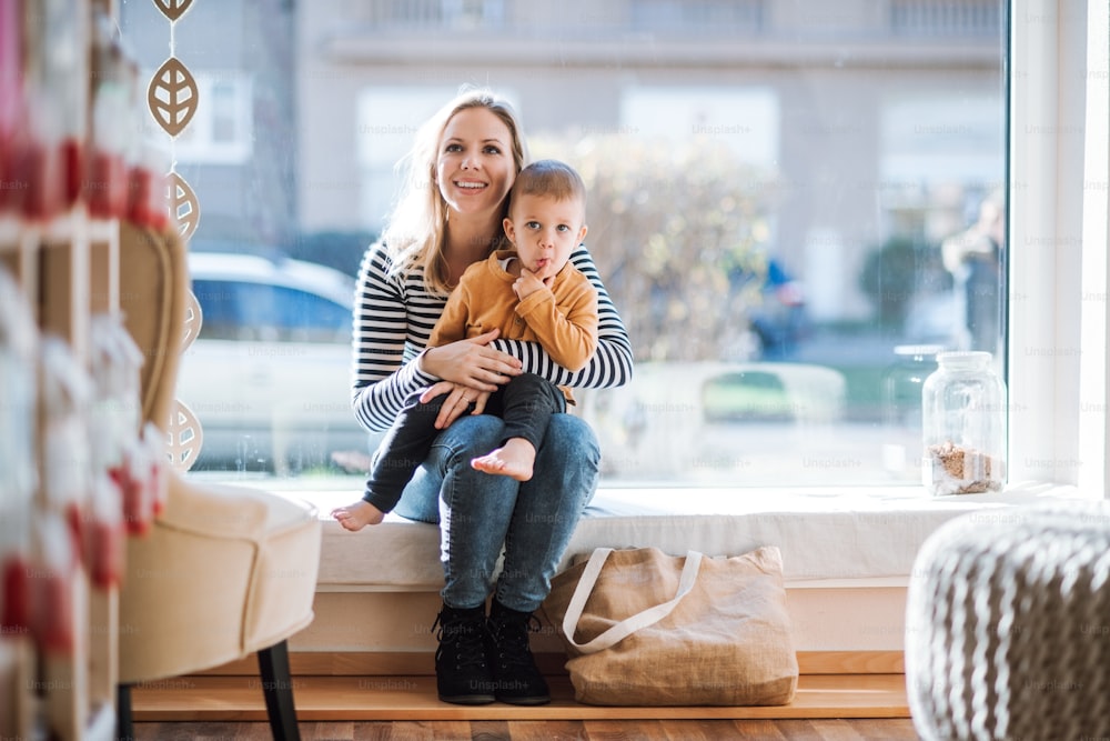 An attractive young woman with a toddler boy buying groceries in zero waste shop, resting.