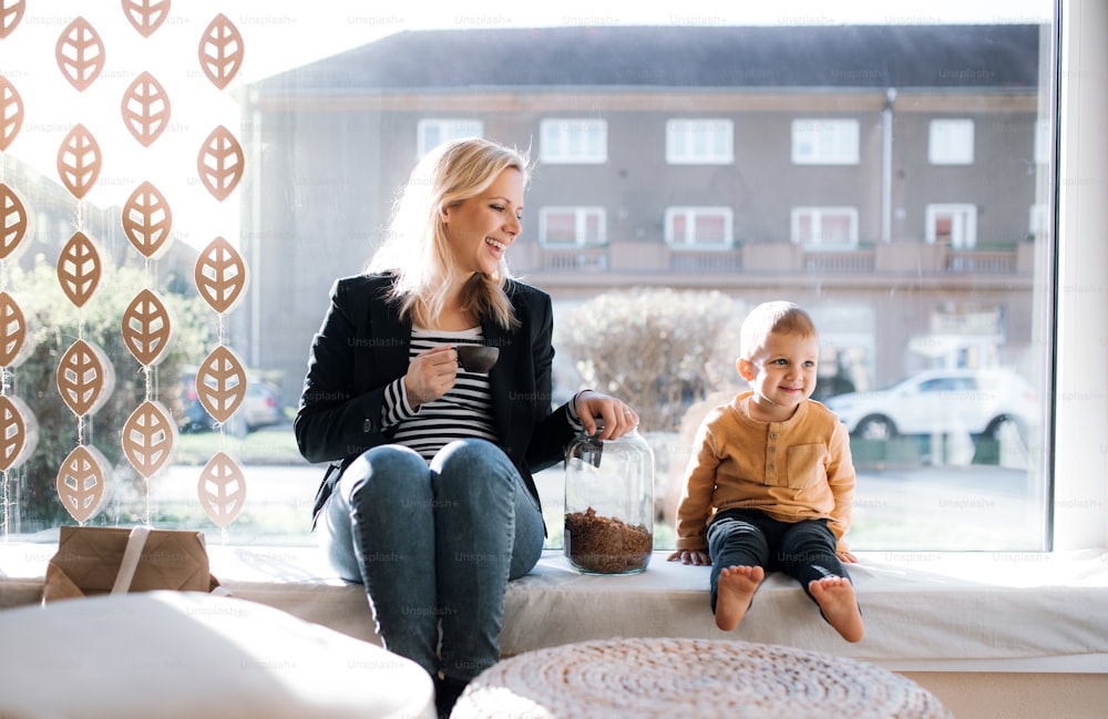 An attractive young woman with a toddler boy buying groceries in zero waste shop, resting.