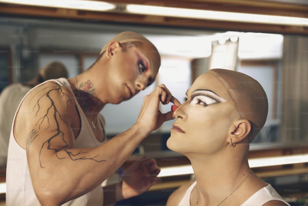 a man putting makeup on a woman's face