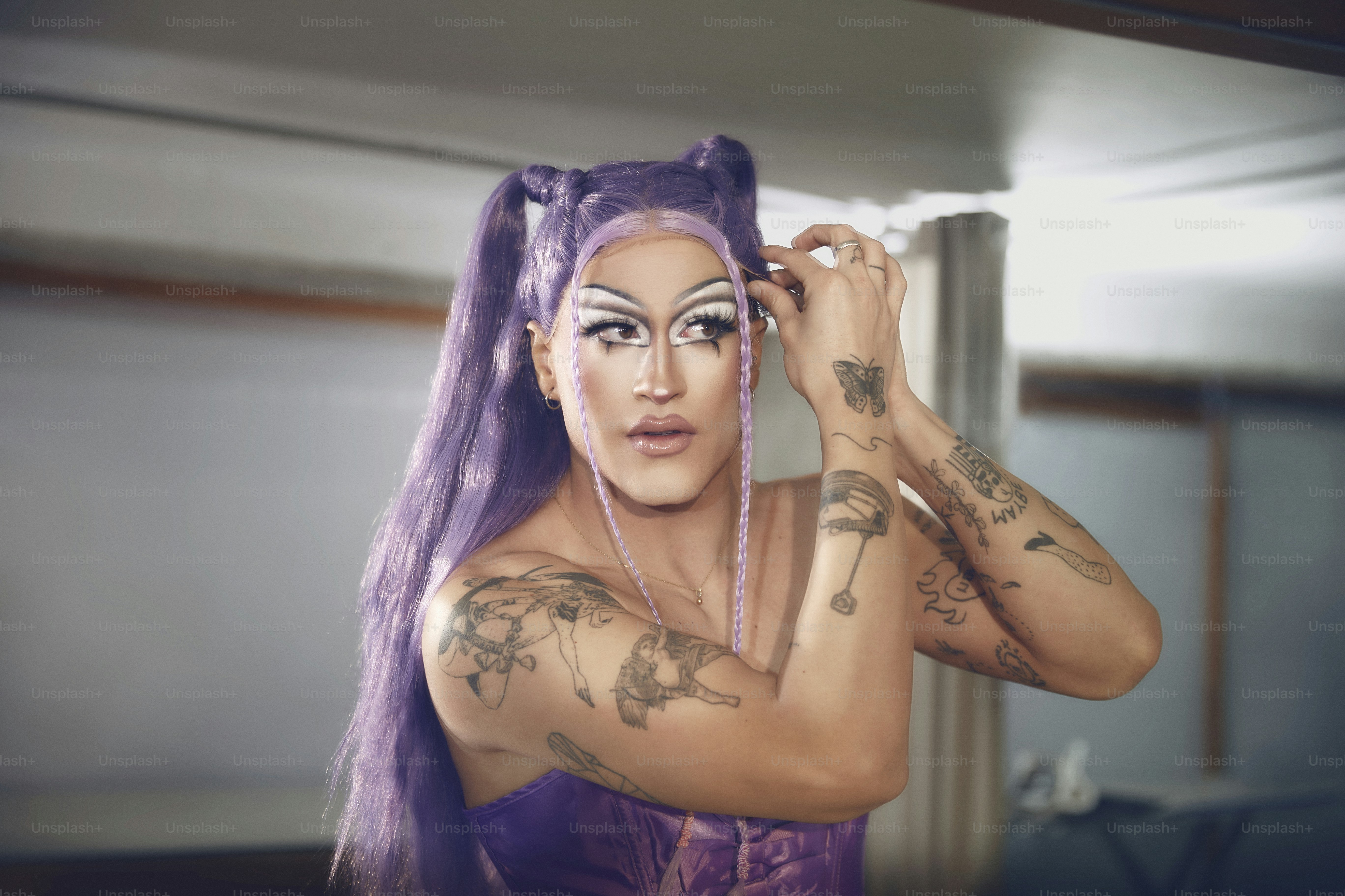 a woman with purple hair and tattoos on her face