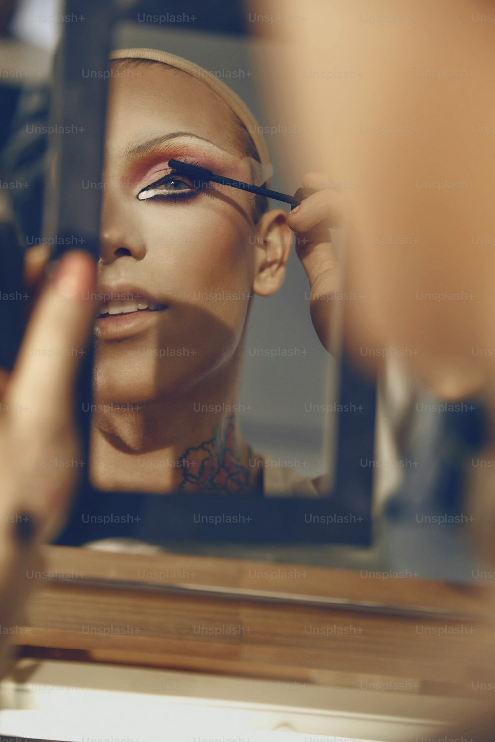 uma mulher está fazendo maquiagem na frente de um espelho