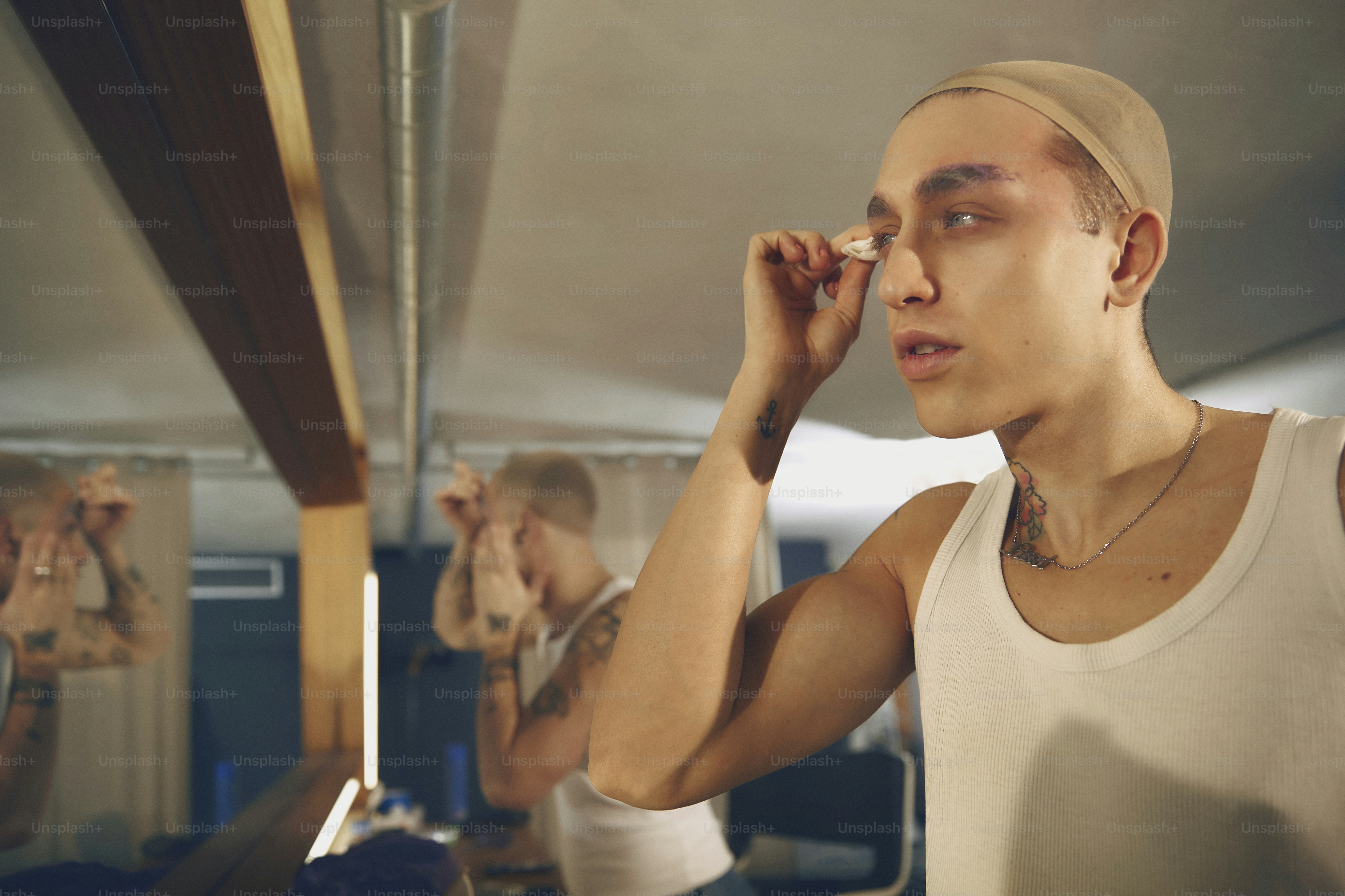 a man with a bald head is looking in a mirror
