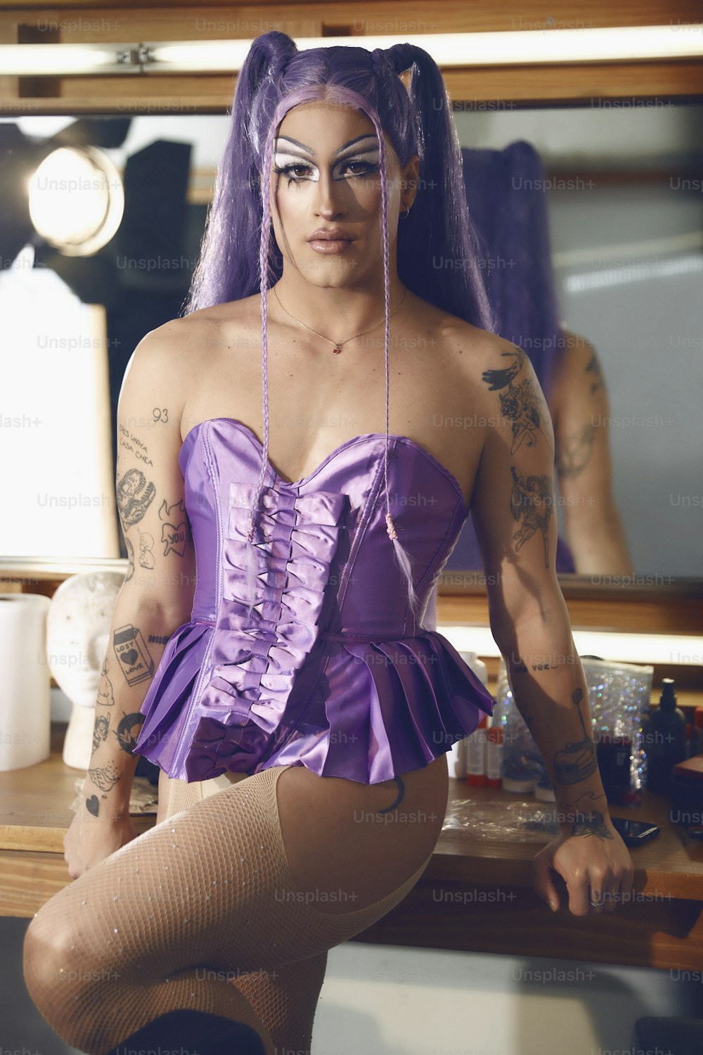 Una donna in un corsetto viola seduta su un bancone