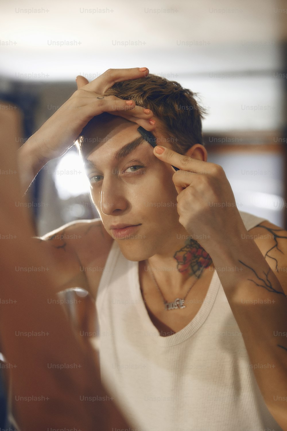 a man with a tattoo on his arm is looking in a mirror