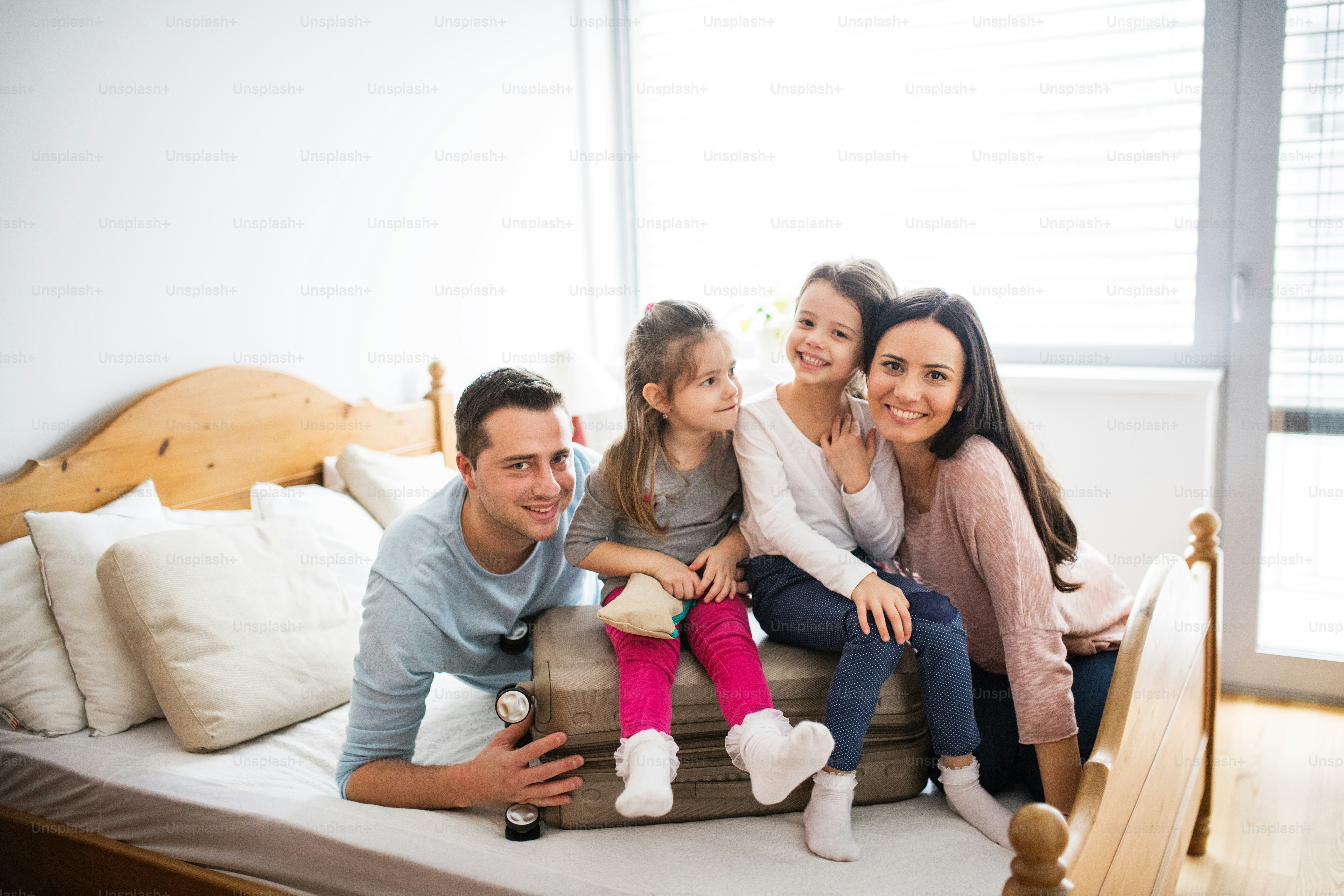 Retrato de una familia joven y feliz con dos niños empacando para las ...