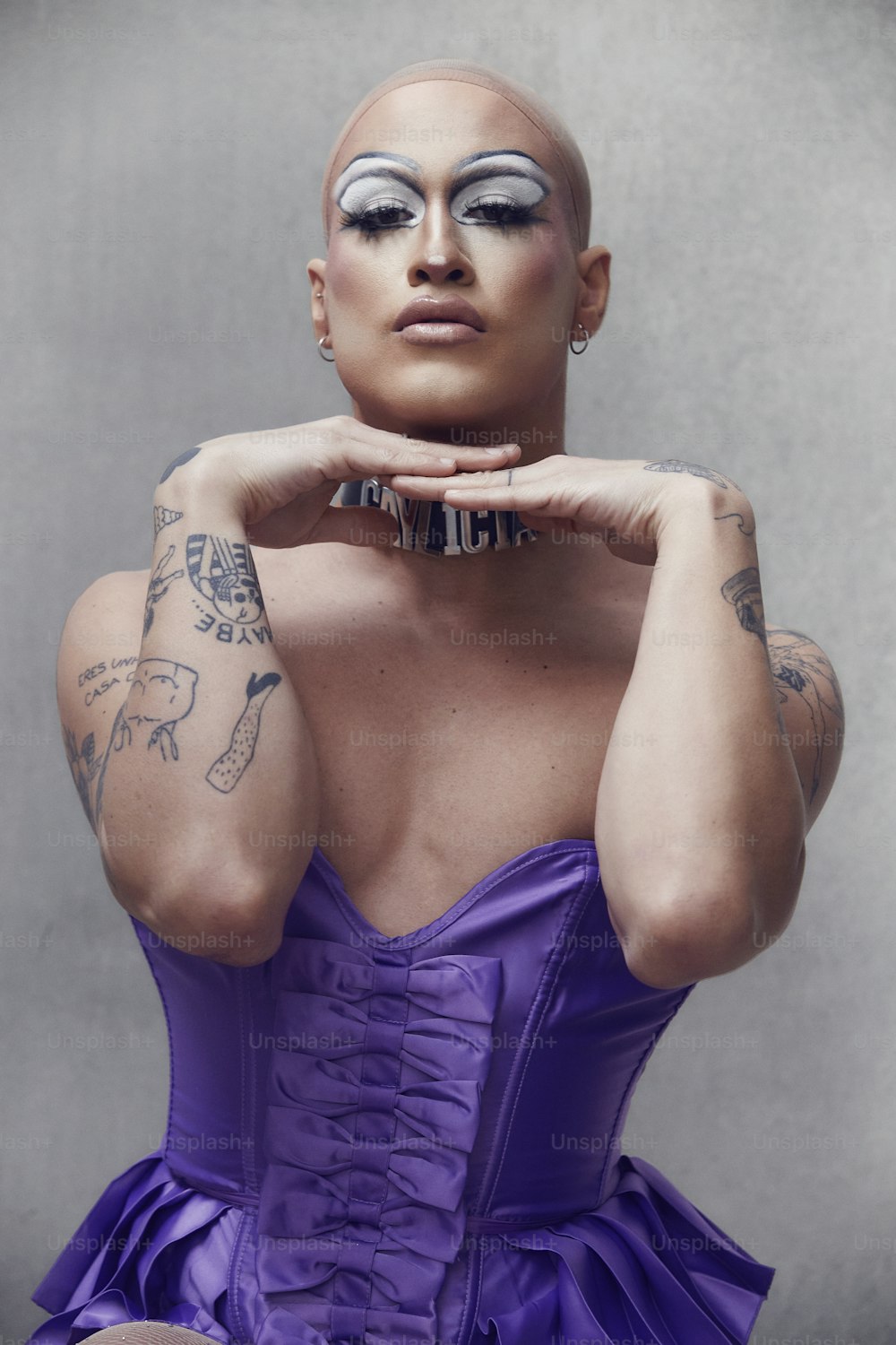 a woman in a purple dress with tattoos on her face