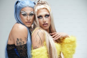 two women with blue hair and makeup posing for a picture