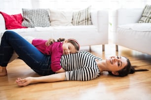 Young mother with a small girl at home, playing.