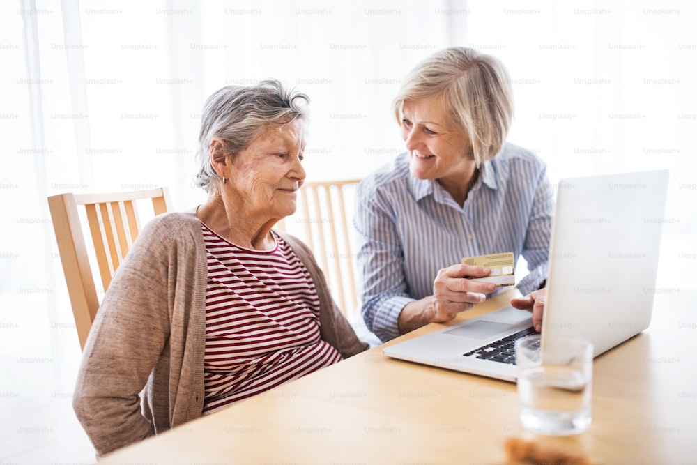 Senior woman with her mother with laptop at home. Family and generations concept.