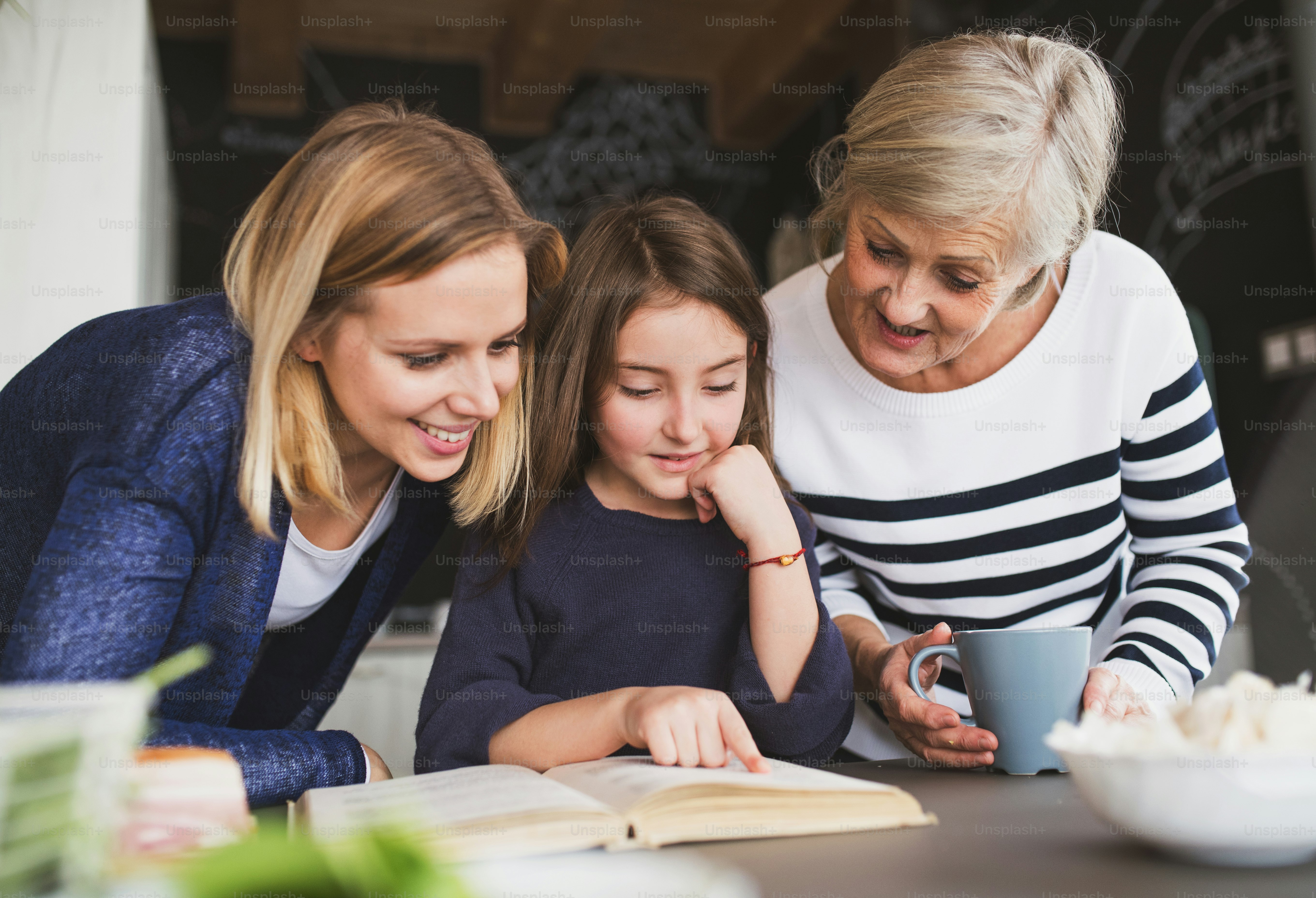 Una niña pequeña con su madre y su abuela en casa. Concepto de familia ...