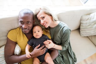 귀여운 아기 아들을 안고 있는 아름다운 젊은 인종 간 가족.