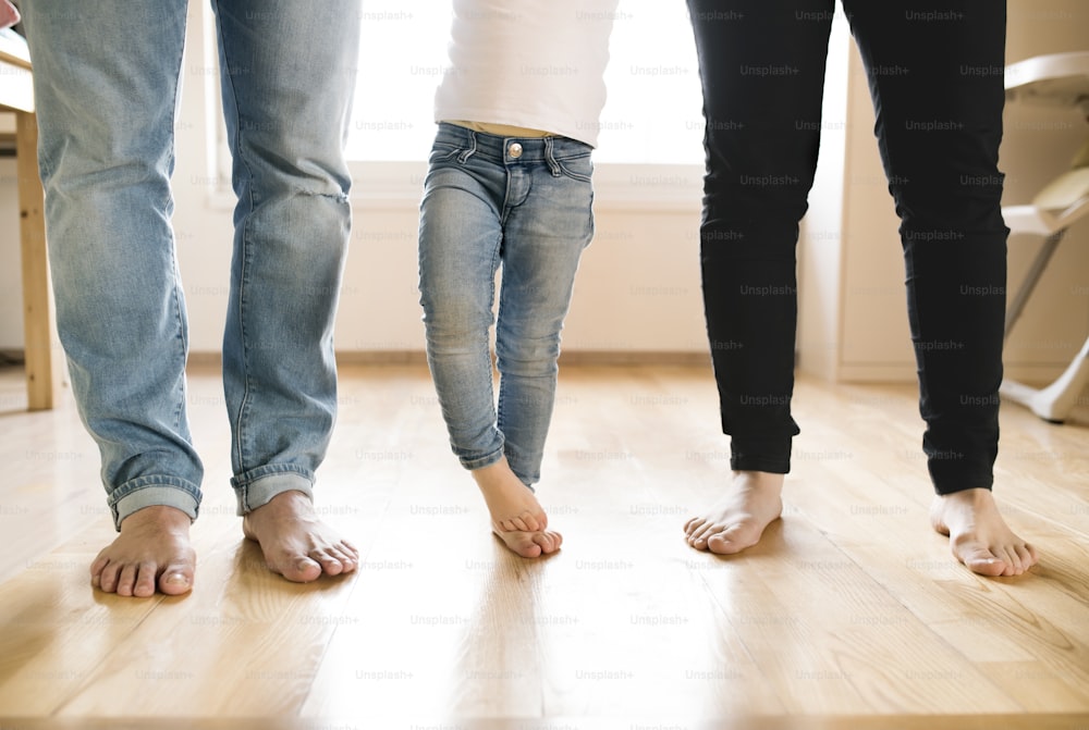 Beautiful young family. Close up of bare feet of mother, father and daughter.