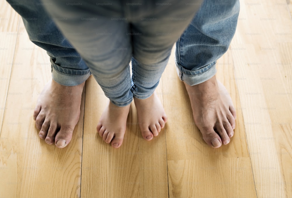 Hermosa familia joven. Primer plano de los pies descalzos de padre e hija.