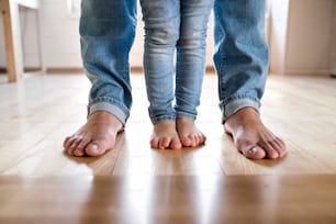 Beautiful young family. Close up of bare feet of father and daughter.