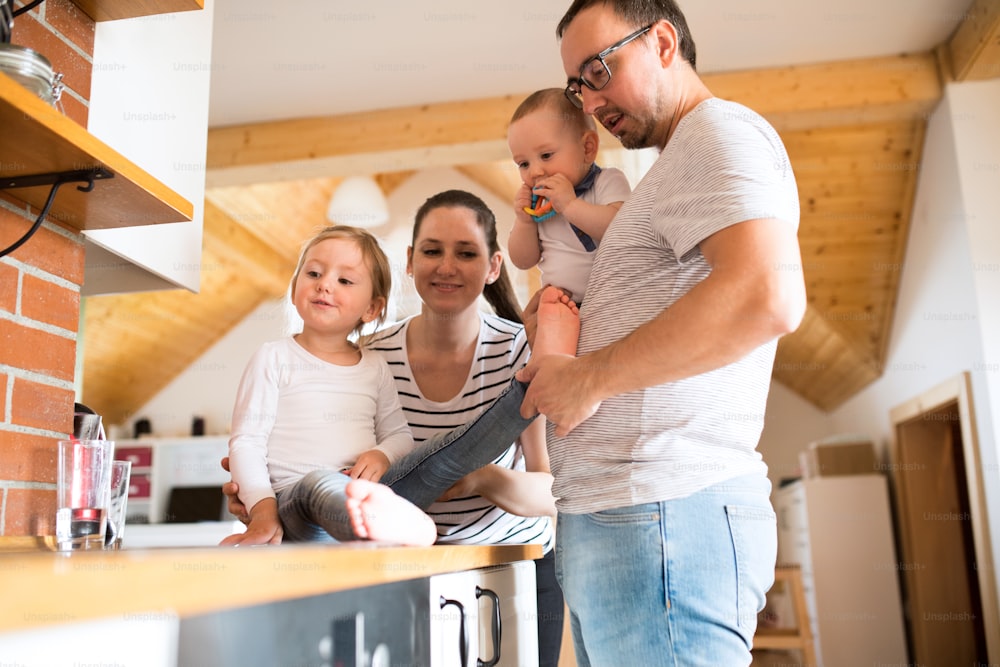 Beautiful young parents at home with their cute son and daughter