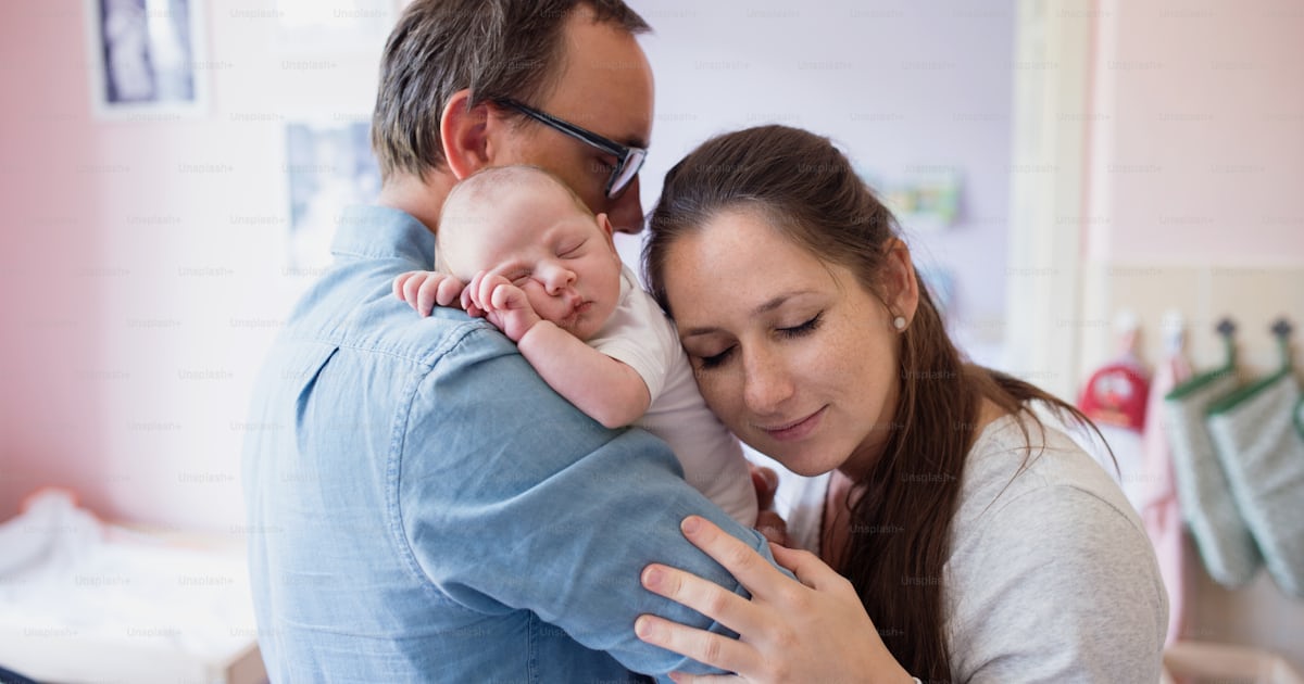Foto zum Thema Junge Vater und Mutter halten ihren neugeborenen Sohn in