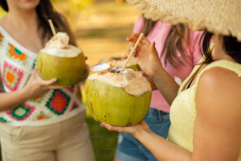 a woman holding a coconut drink in her hand