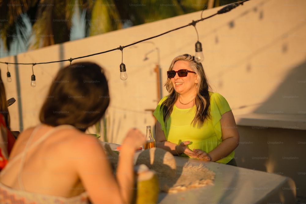 Una mujer sentada en una mesa con una copa de vino