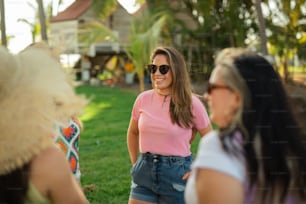 a woman wearing a pink shirt and denim shorts
