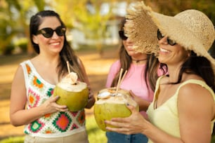 a group of women standing next to each other holding coconuts