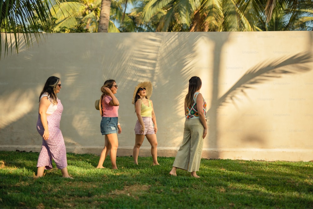 Un grupo de mujeres de pie junto a una pared blanca