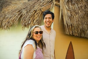 Un homme et une femme debout devant une hutte