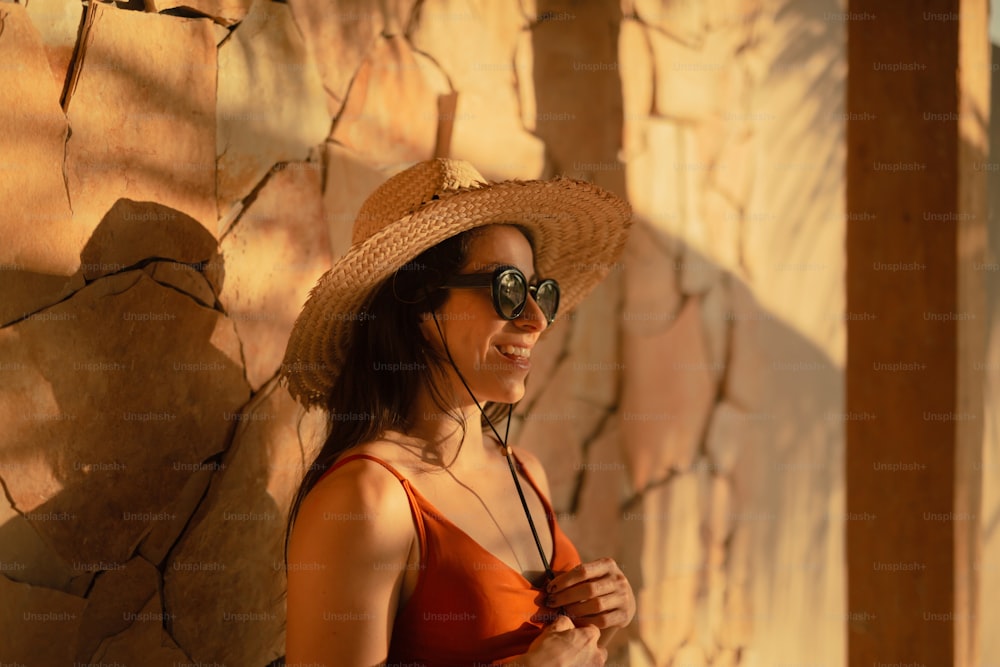 uma mulher que usa um chapéu de palha e óculos de sol