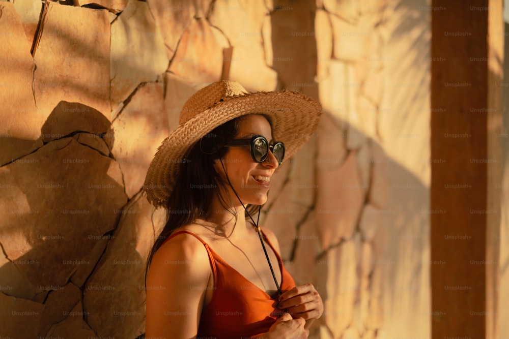 a woman wearing a straw hat and sunglasses