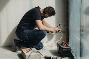 a man working on a wall with tools