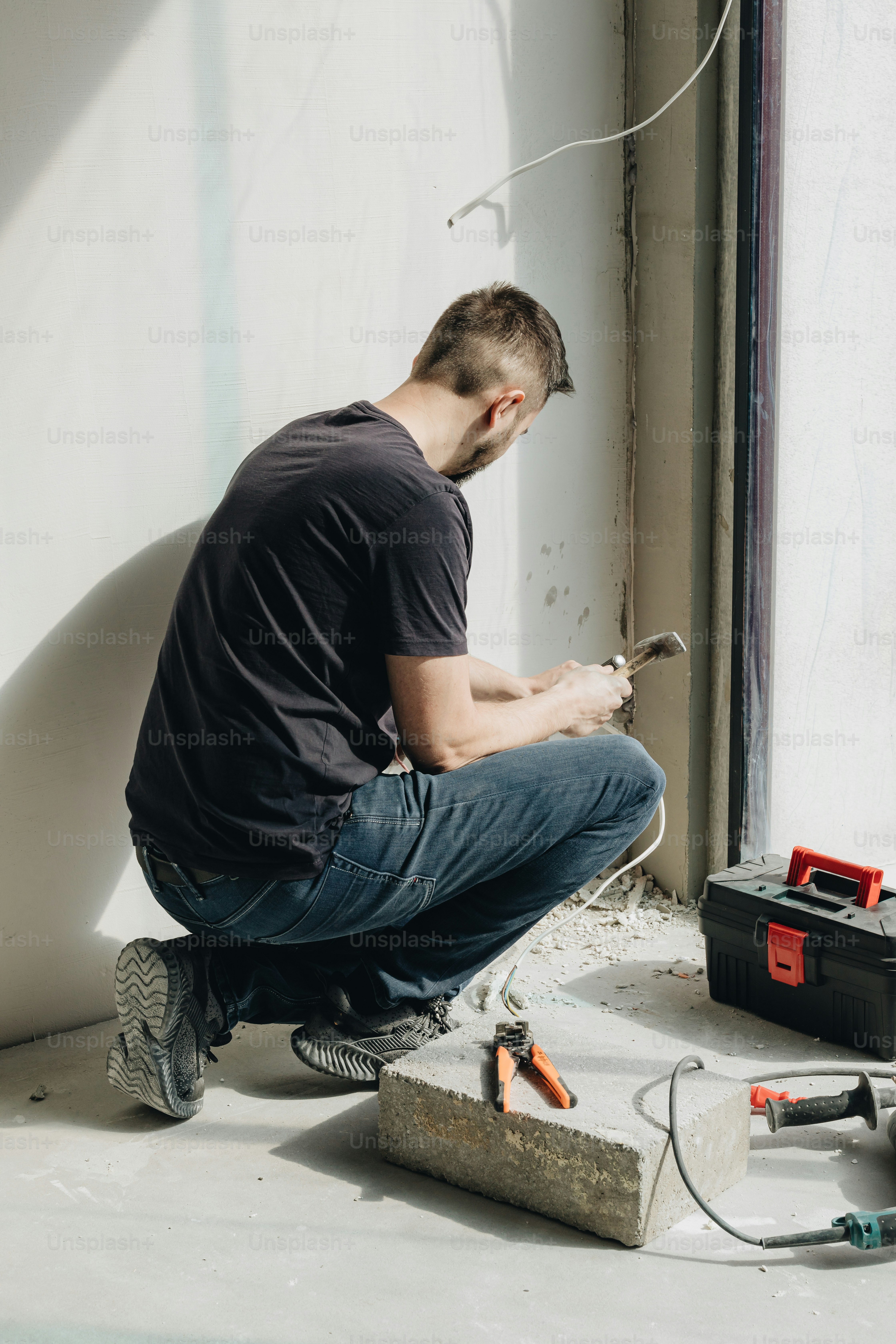 地面に座って壁に取り組んでいる男性