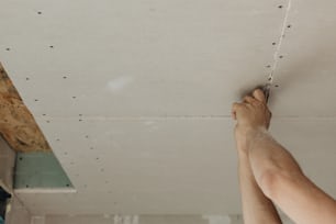 um homem está trabalhando em um teto em uma sala