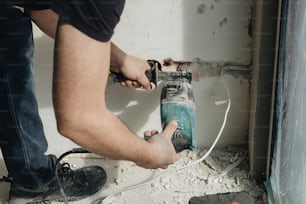 a man using a power drill to fix a hole in a wall